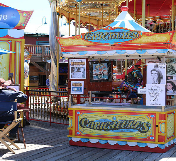 Caricatures stand in front of the carousel